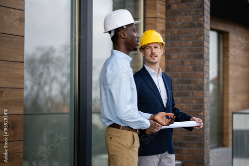 Fotografia Architects discussing construction plan on building site
