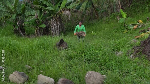 A man carrying a big stone for landscaping