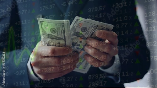 Businessman counting US dollar bills overlaid with fluctuating stock market ticker numbers and financial line charts. Currency exchange and economy.