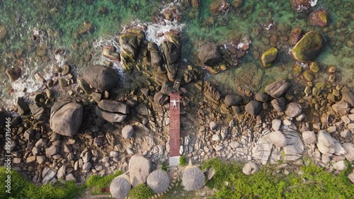 Aerial Descending Drone Shot Approaching Person Lying on Wooden Bridge Rocky Coastline Ko Tao Thailand 4K