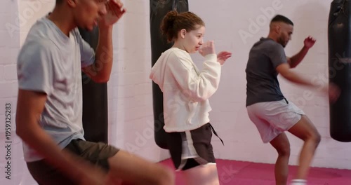 At drill start Diverse training partners punching and front kicking on red mat for skill practice