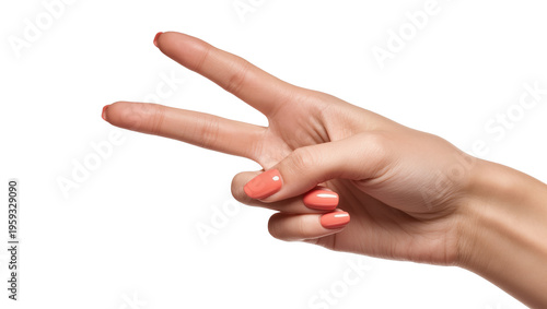 Close-up of elegant woman's hand displaying peace sign with fashionable peach nail art