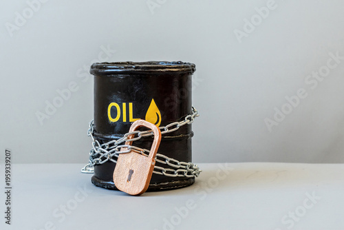 An oil barrel locked with a chain and padlock. Energy crisis, fuel supply constraints, fuel shortage, supply control, economic concept, inaccessibility of oil resources. War Iran
