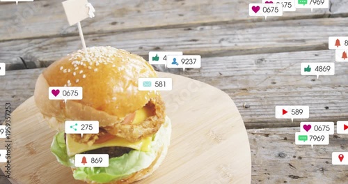 Vertical video: Floating badges moving from right over burger on wood board, showing rising likes