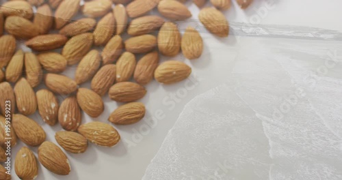 Vertical video: Shifting camera refocusing over almonds on plate, revealing texture on thin film