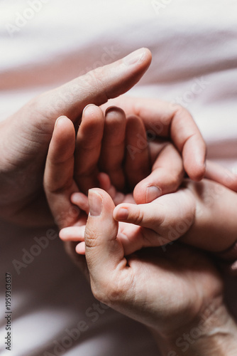 фотографія Close-up image displaying the tender connection between an adult and baby hands