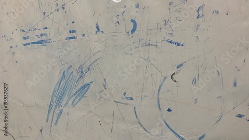 Whiteboard surface covered with faded blue marker stains and random scribble marks