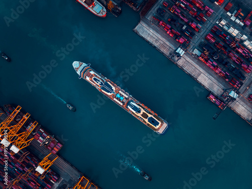 Large Cruise Ship Navigating Through A Bustling Industrial Shipping Harbor During A Cloudy Day