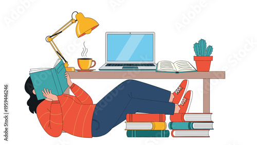 Young woman lying on the floor under a desk reading a book with a laptop and coffee cup visible on the table above her as she studies.