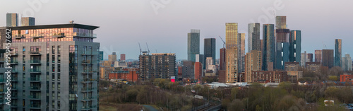 Fotografie Aerial panorama featuring modern apartment blocks and the dense skyscraper cluster of Deansgate Square at dusk, Manchester, UK