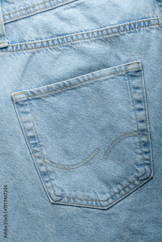 Back pocket of light blue denim jeans in close up shows clean stitching and fabric texture for apparel design and fashion mockup