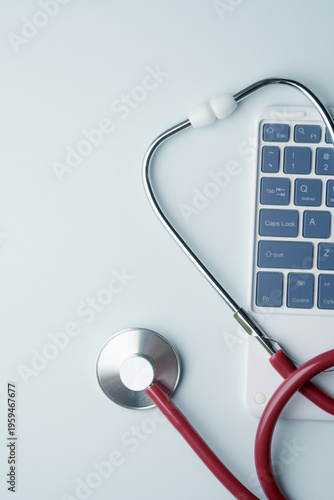 Stethoscope lies on computer keyboard for digital healthcare, telemedicine support and modern medical technology concept.