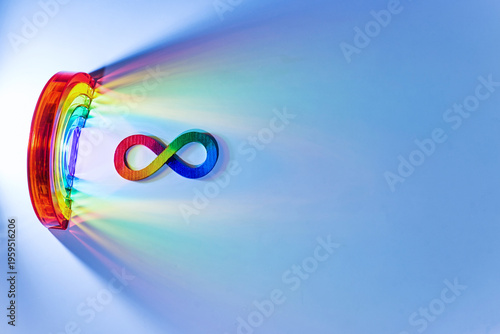 Infinity symbol with rainbow light spectrum on blue. Autism awareness,