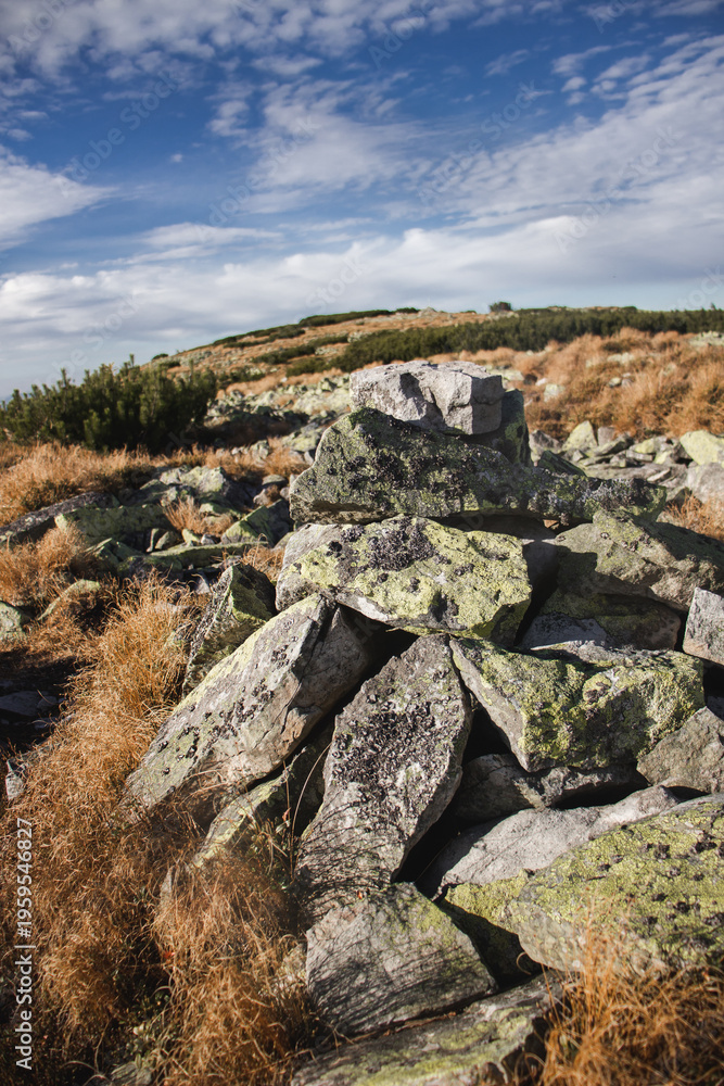 Fototapeta premium Stone cairn on mountain trail in Ukrainian Carpathians under blue sky