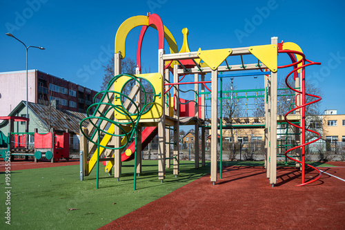 Children can enjoy slides and climbing equipment in a city playground on a clear day