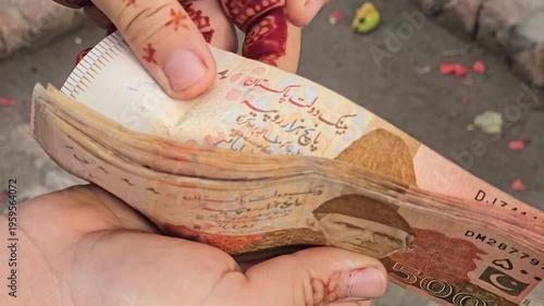Five Thousands Pakistani bank currency notes held in hands showcasing a stack of various denominations with visible details