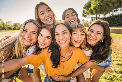 Multi ethnic group of young women hugging outside - Happy girlsfriends having fun laughing out loud on city street - Female community concept with cheerful girls standing together - Women  power