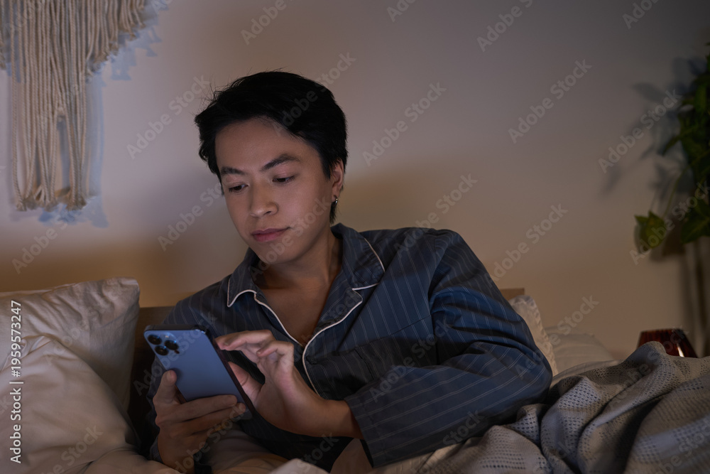 Fototapeta premium Modern man enjoys relaxed evening with phone in cozy apartment setting
