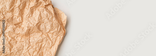 Crumpled brown paper, parchment, kraft paper on gray background top view. Abstract background, baking paper texture, empty space for text or inscriptions. Backdrop for your design