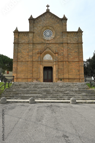 Neo-Gothic architecture of the Church of the Immaculate Conception in Piombino, Tuscany. Its historic stone façade features a decorative rose window