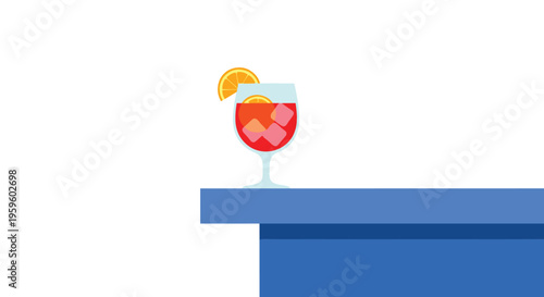 A vibrant red cocktail with an orange slice and ice cubes rests in a stemmed glass on the edge of a solid blue table.