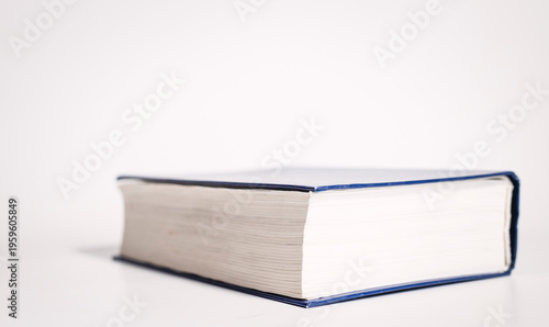 Φωτογραφία Closed thick book with white cover placed on white background, side view