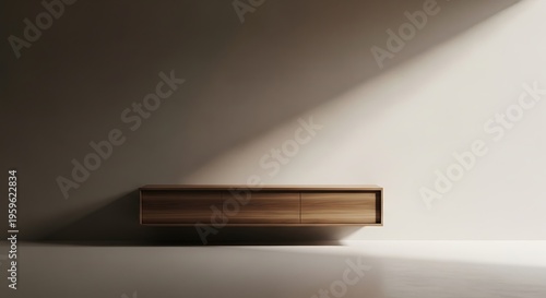 Minimalist wooden floating cabinet on a light wall with dramatic diagonal sunlight and shadow.