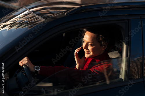Woman driving car and talking on smartphone