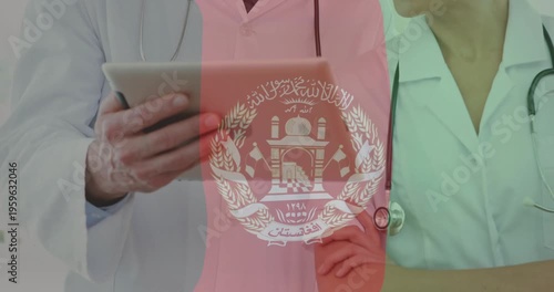 Using tablet, doctors with stethoscopes and Afghanistan emblem overlay in animation