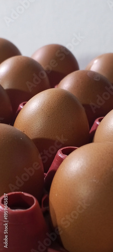 Close-up of fresh brown chicken eggs arranged in a tray with soft natural lighting. This image highlights texture and organic quality, perfect for themes related to food, nutrition, agriculture, and h