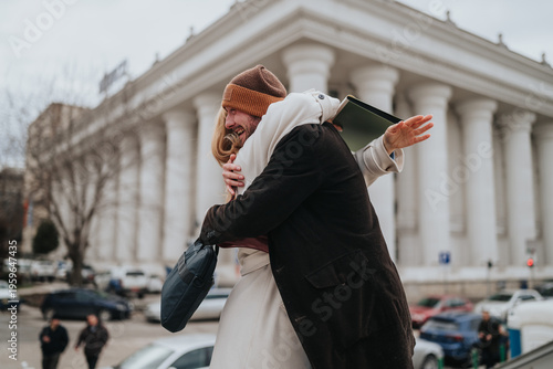 A couple warmly hugs in front of a neoclassical building, smiling and reunited. The joyful embrace captures a candid city reunion outside a landmark courthouse.