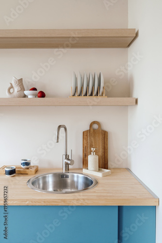 Modern kitchen area with minimalist sink, faucet and wooden countertop