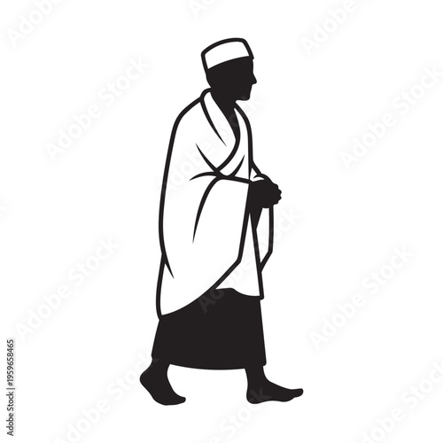 Man dressed in Ihram clothing walks in profile wearing a traditional cap.