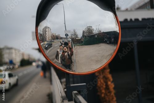 Cuadro en lienzo Two men take a selfie reflected in a convex traffic mirror on a city sidewalk