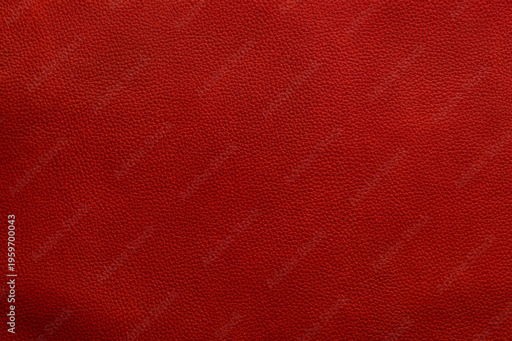 Fototapeta premium Close up view of red textured surface showing details of leather material in natural light capturing its unique pattern and color