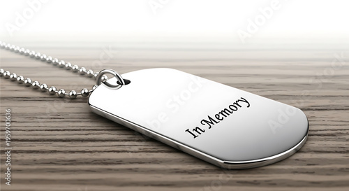 A silver dog tag necklace with a chain lies on a wooden surface with the words 'In Memory' engraved on it.