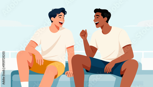 Two men laugh while sitting on a blue couch. They wear matching white t-shirts and casual shorts. Their joyful expressions show friendship and ease