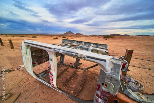 Abandoned Vehicle Shell in Nevada Desert with Mountains and Dramatic Sky