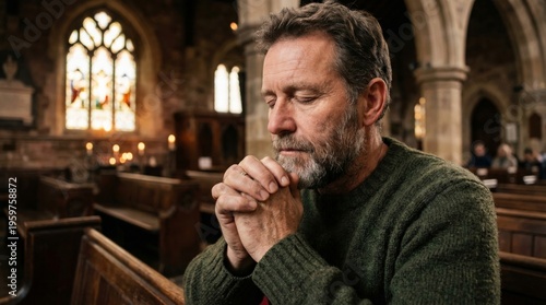 Mature man praying in church with hands clasped. Devout faithful person seeking spiritual guidance and connection. Religious belief, christianity, faith, worship and inner peace concept.