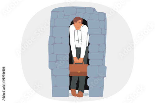 Depressed business man stands in narrow stone doorway symbolizing pressure of circumstances. Frustrated manager suffering from pressure caused by poor working conditions in corporation