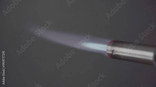 Close up flame of cooking gas blow torch over black background, side view. High quality FullHD footage