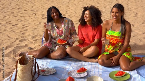 Group of happy multiracial women doing picnic and eating watermelon during summer beach vacation - Holiday, friendship and young diverse people concept