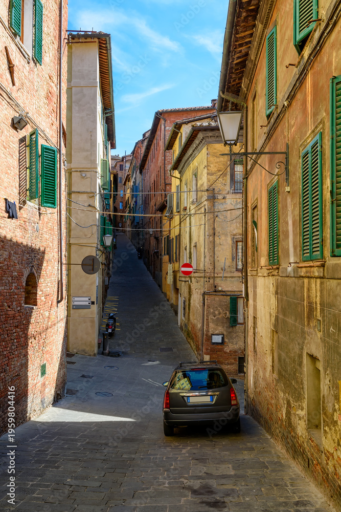 Fototapeta premium Medieval narrow street in Siena, Tuscany, Italy. Architecture and landmark of Siena. Cozy cityscape of Siena