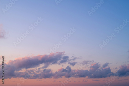 A background image of an orange-blue sky with dark clouds at sunset on a winter evening. Beautiful gentle sunset.