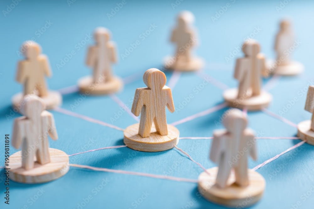 Obraz premium Networked Relationships: Wooden figurines connected by lines, representing interconnectedness and communication in a blue setting.