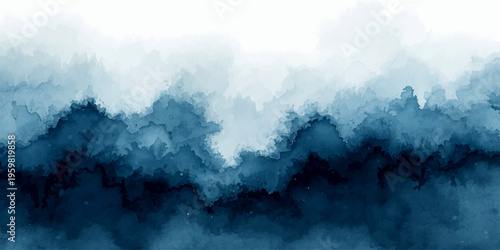 A breathtaking alpine landscape features snow-covered peaks under a cloudy blue sky as white fog drifts over the high mountain range during a bright summer day