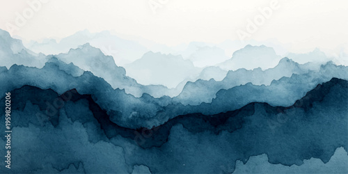 A high aerial view of a misty mountain landscape where snow peaks touch the blue sky above a morning forest valley and clouds