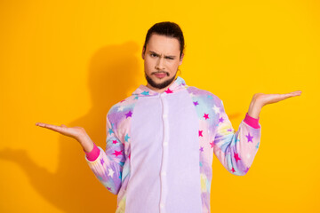 Confident man in pastel star pajama poses with open hands against a bright yellow background for sleepwear lifestyle and fashion stock photo