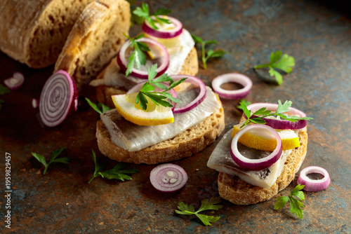 Konstfotografi Open sandwiches with herring filet, red onion, lemon, and parsley