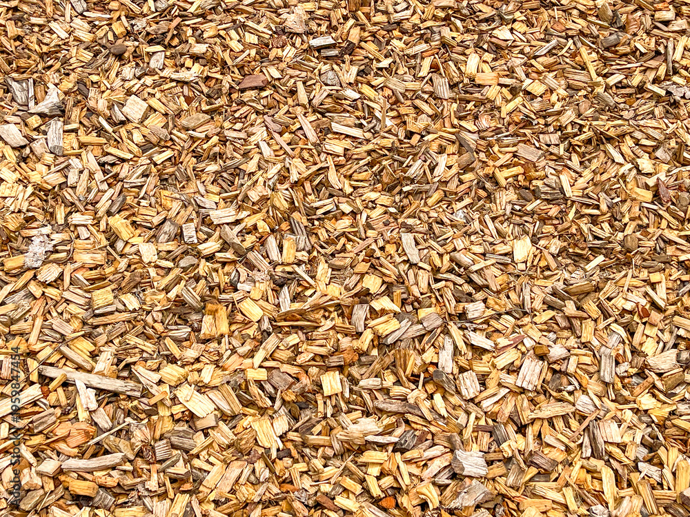 Fototapeta premium Wood chips of various sizes on the ground in a garden to form a barrier against weeds. Backgrounds